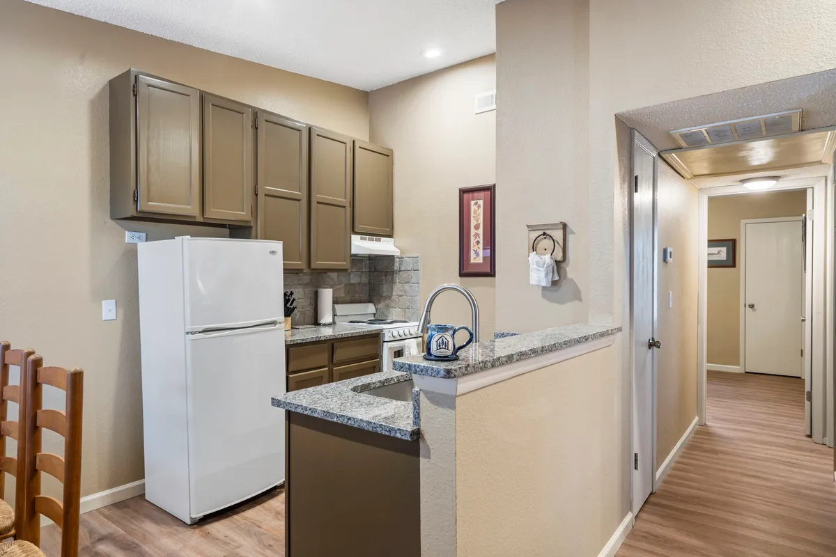 A modern kitchen area featuring granite countertops, up-to-date appliances, and decorative wall art. The space is designed for cooking, entertaining, and family gatherings, with ample room for meal preparation and social interaction.