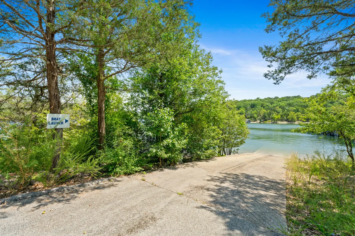 A boat launch area with clear signage, a paved ramp leading into the water, surrounded by greenery—designed for effortless boating and water activities.