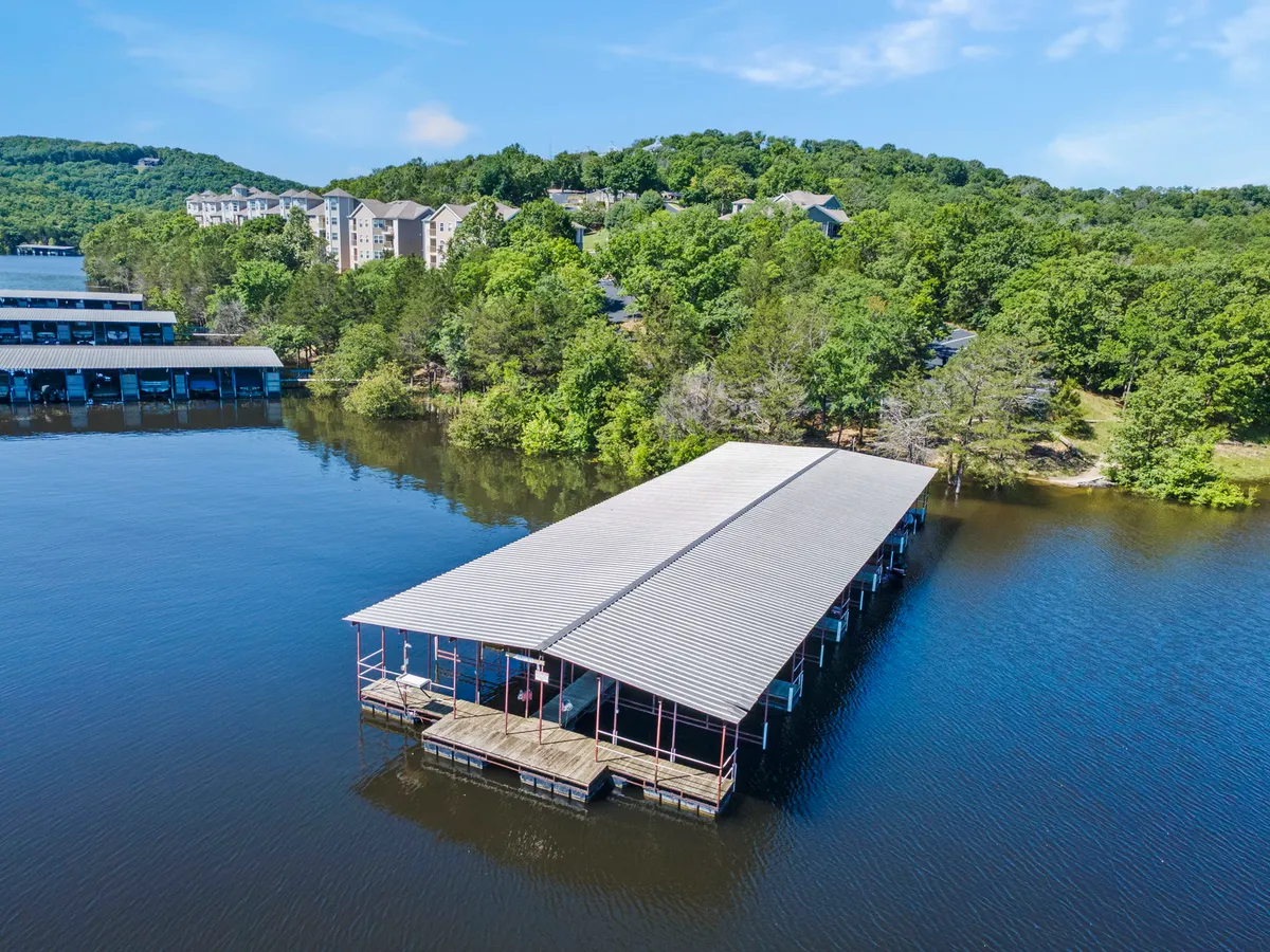 This view shows a tranquil dock extending over the water, flanked by greenery and with buildings in the distance. The scene hints at opportunities for boating, fishing, and unwinding by Table Rock Lake, a key highlight of the resort’s location.