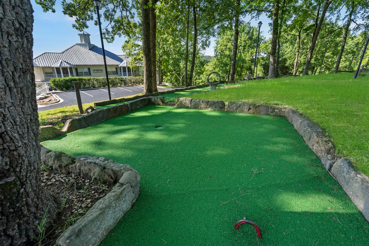 A playful mini-golf area set among natural green surroundings and rock formations, inviting for family games and friendly competitions.