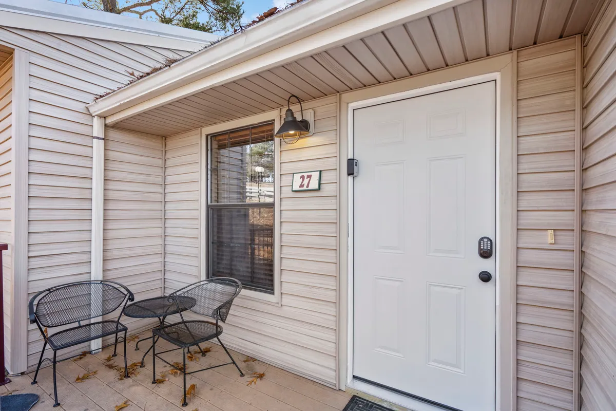 An exterior shot of the welcoming front porch, complete with comfortable seating and the number 27 visible. The inviting setup hints at private outdoor moments—morning coffees, sunset chats, and a sense of home-away-from-home for couples seeking intimacy and comfort.